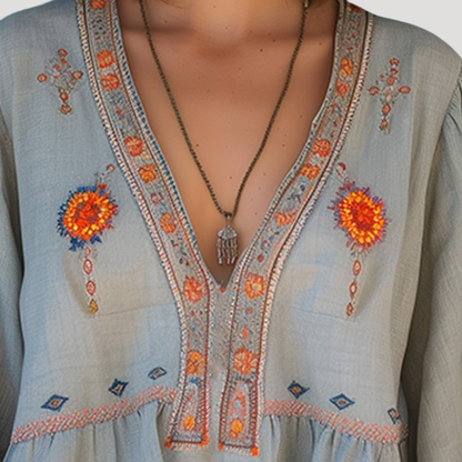 Breezy blouse featuring intricate floral embroidery and a stylish V-neck design, perfect for a casual yet elegant look. 1